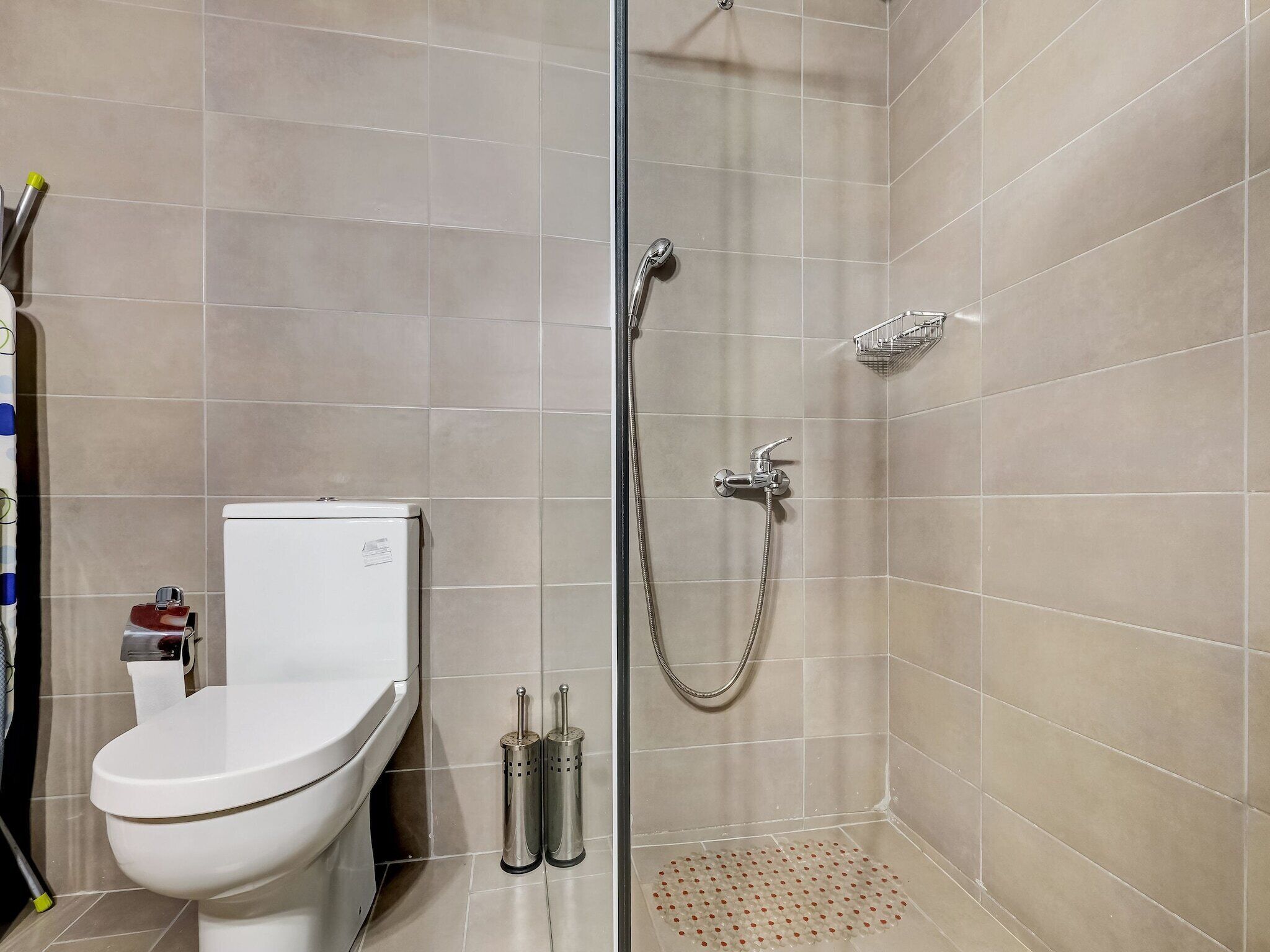 Et badeværelse med toilet, bidet og bruseområde.