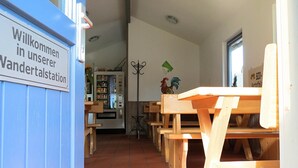 Un espace avec des bancs en bois et une pancarte indiquant : « Bienvenue à notre relais de randonnée ».