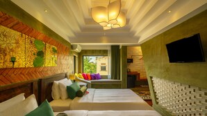 A hotel room with two beds, a large window, a television, and a decorative wall.