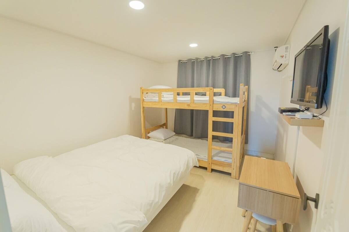 Dormitorio con literas, escritorio y televisión.