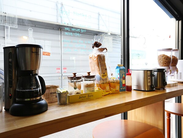 En køkkenbordplade med kaffemaskine, brød og forskellige spiser.