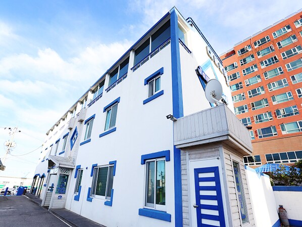 Un bâtiment blanc avec des bordures bleues et de nombreuses fenêtres.