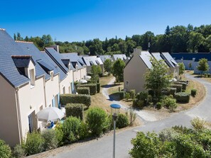 Ein Wohngebiet mit mehreren Häusern, blauem Himmel und einem gepflegten Garten.