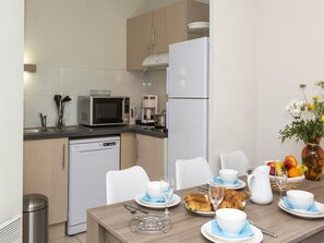 A compact kitchen with a microwave, coffee maker, and dishwasher.