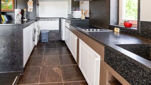 A compact kitchen with a washing machine, a microwave, and a sink.