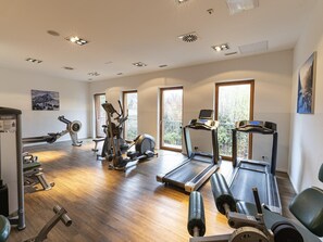 Une salle de sport équipée de tapis de course, de vélos elliptiques et de matériel de musculation.