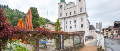 A historic building with two towers and a paved walkway in front.
