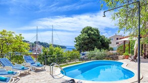 A swimming pool with lounge chairs and a stone patio. - Villa in Sumartin near Beach & Private Pool (Sumartin)