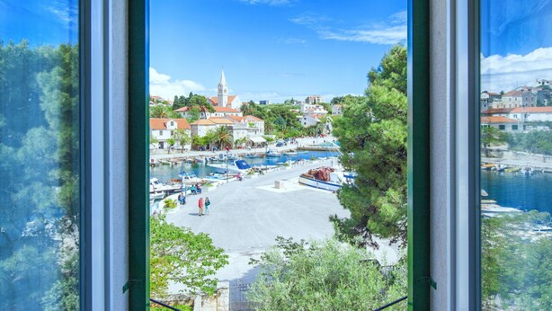 A coastal town with a central square, boats docked along the waterfront, and a prominent church with a tall spire. - Villa in Sumartin near Beach & Private Pool (Sumartin)