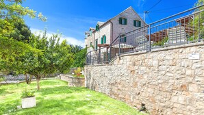 A stone building with a balcony, surrounded by a well-maintained lawn and trees. - Villa in Sumartin near Beach & Private Pool (Sumartin)