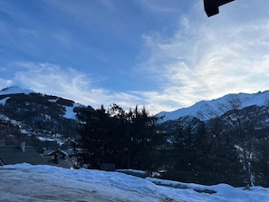 A mountainous landscape with snow-covered peaks and a clear sky.
