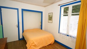 A bedroom with a single bed, two doors, a window with curtains, and a ceiling light. - Wildlife Haven Near Le Pouldu (Clohars-Carnoet)