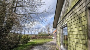 A pathway leading to a building with a green siding exterior. - Holiday Home Schoonoord near Kibbelkoele (Kibbelveen)