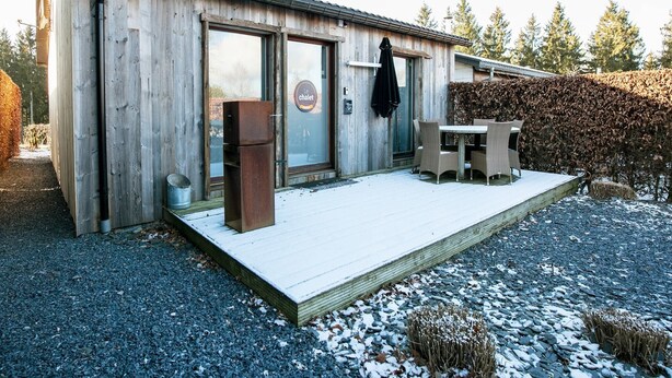 Ein Holzhaus mit Glastür und einem Schild, auf dem 'le chalet' steht.