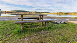 Ein Picknicktisch am See unter einem klaren Himmel.