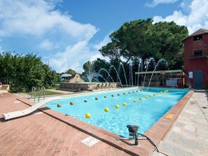 Relax by the clear pool surrounded by a brick deck, with a soothing fountain nearby.
