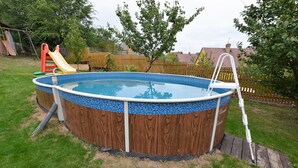 A round above-ground pool with a wooden exterior and a ladder. - Holiday Home in Forest with Private Pool (Petrohrad)