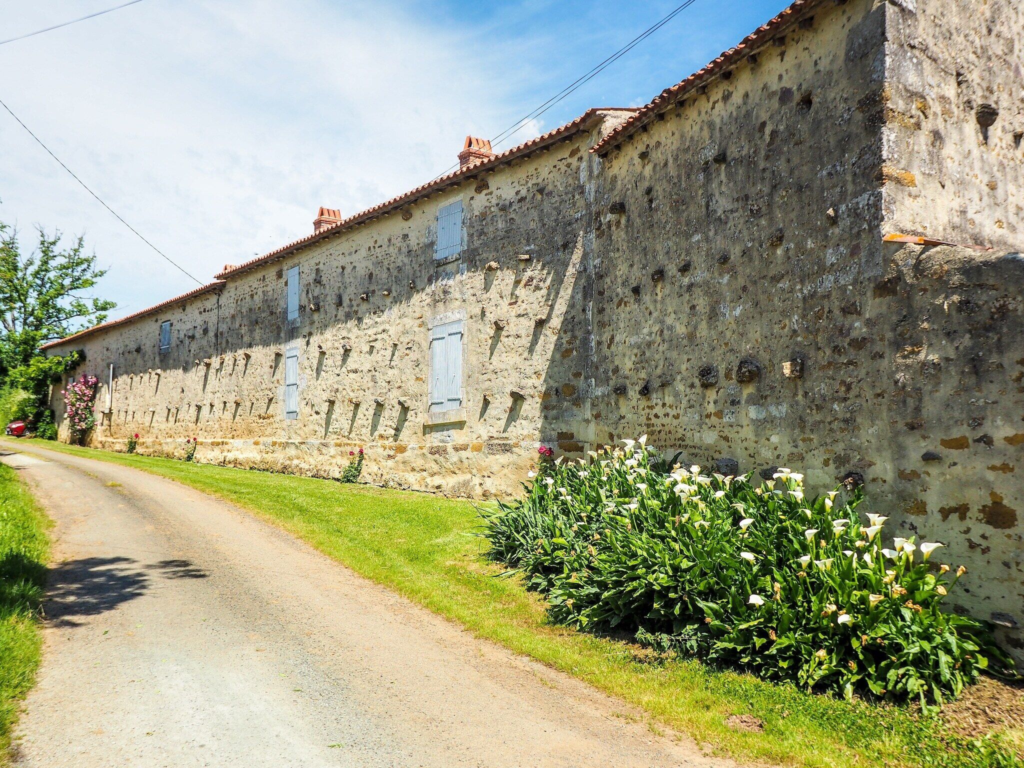 A rustic stone building with a dirt road in front.