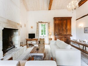 Un salon avec une cheminée, un téléviseur, un canapé et un meuble en bois.