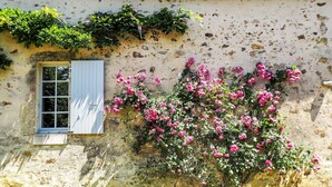 A rustic building with a window and a wall covered in pink flowers. - Holiday Home Saint-Laurent Pool & Garden (St. Laurent de la Salle)