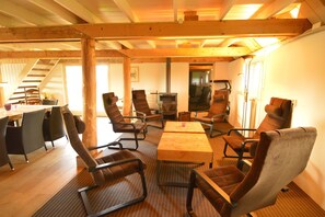 A cozy room with a wooden ceiling, a fireplace, and comfortable seating. - Farmhouse in Dalfsen near Forest Trails (Dalfsen)
