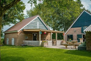 A rustic building with a covered porch and picnic tables. - Farmhouse in Dalfsen near Forest Trails (Dalfsen)