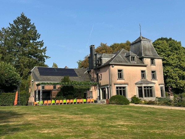 Ein großes, zweistöckiges Gebäude mit einem markanten Turm und einer Solaranlage auf dem Dach.