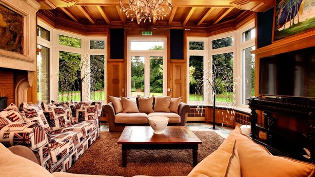 A spacious room with a large sofa set, a television, and a chandelier. - Luxury Estate with Pool & Spa (Jamoigne)