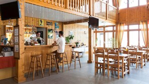 A wooden interior with a bar area, seating, and a television. - Chalet Apartment by Lake Geneva, Evian (Bernex)