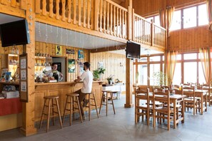 Ein Holzinterieur mit Bar, Sitzgelegenheiten und einem Fernseher.