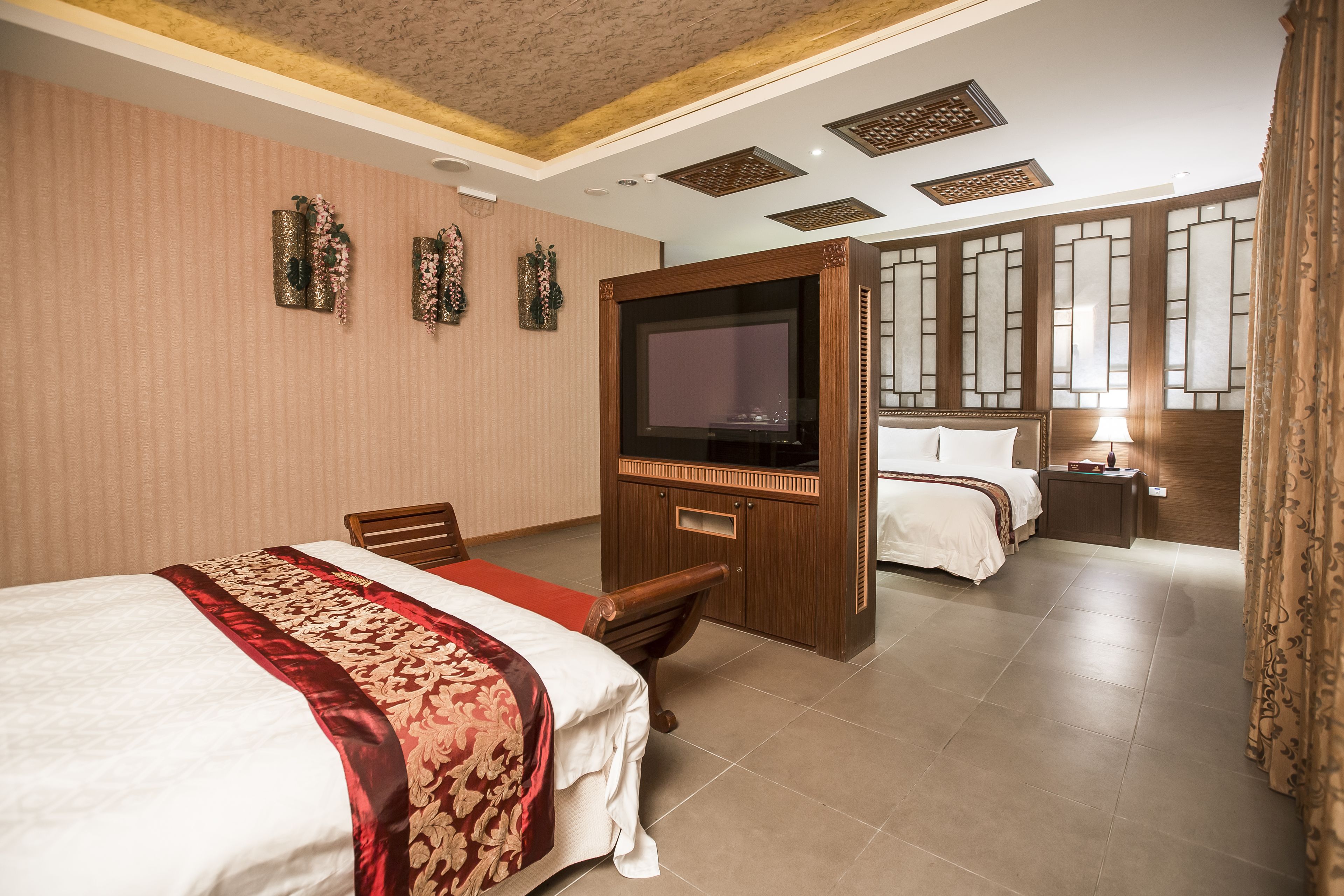 A hotel room with a large bed, a TV, a desk, and a separate sleeping area.