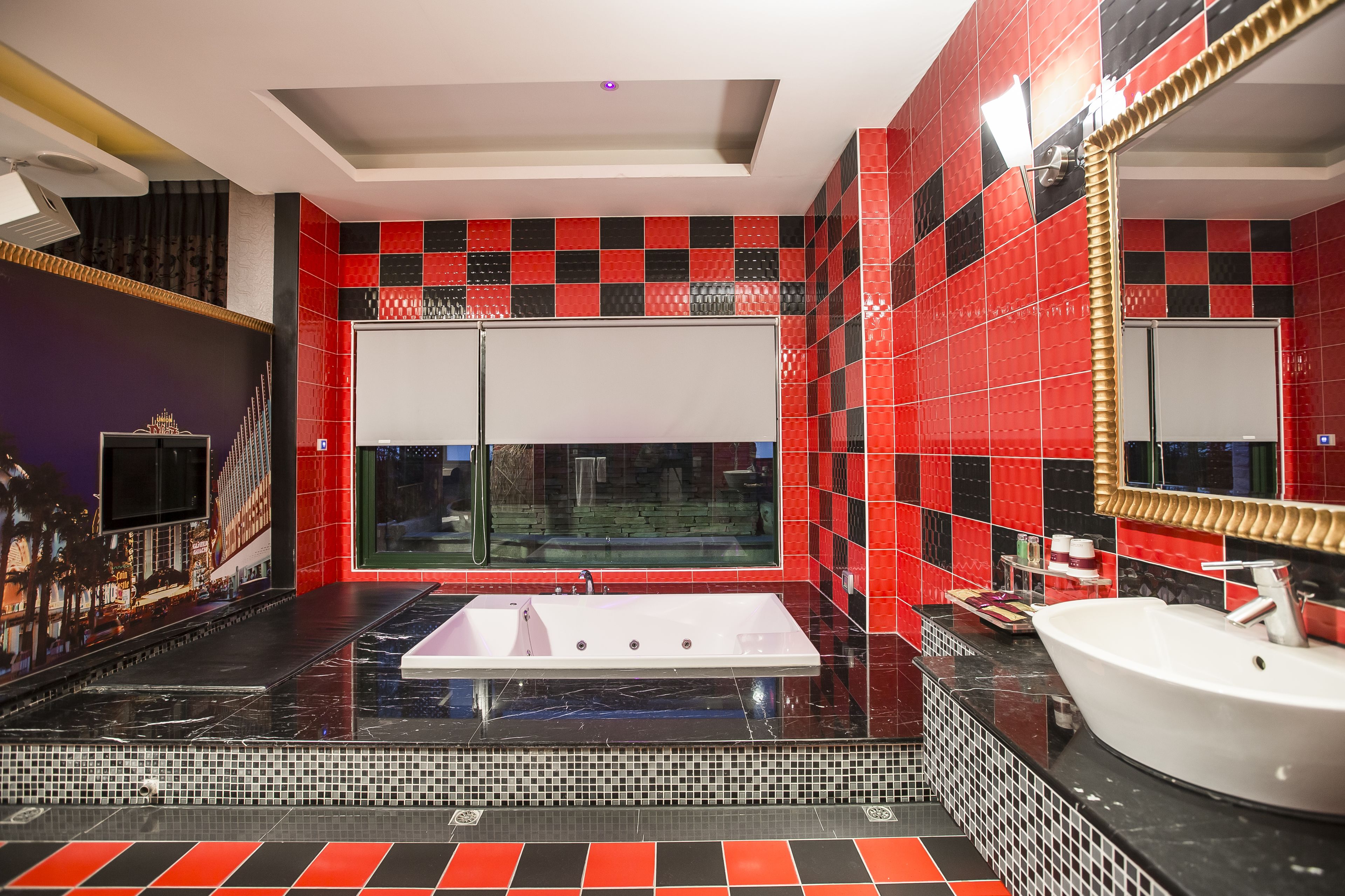 A modern bathroom with a large bathtub, a separate sink, and a large mirror.