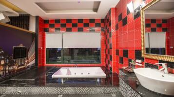 A modern bathroom with a large bathtub, a separate sink, and a large mirror.