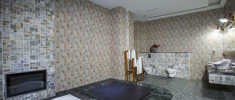 Un baño moderno con una bañera grande, zona de ducha y un inodoro.