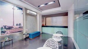 Un vestíbul d'hotel modern amb una finestra gran, una banca blava i una taquilla d'eixida.