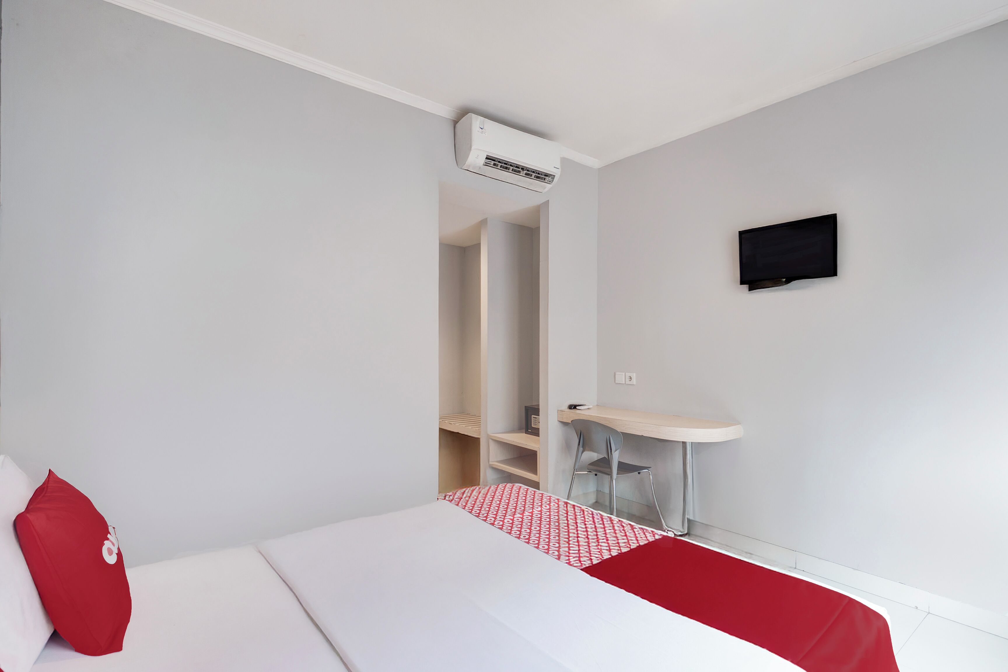 Une chambre d’hôtel équipée d’un lit, d’un bureau, d’une chaise, d’une petite table et d’un appareil de climatisation.