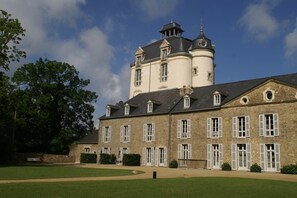 A large stone building with multiple windows and a tower.