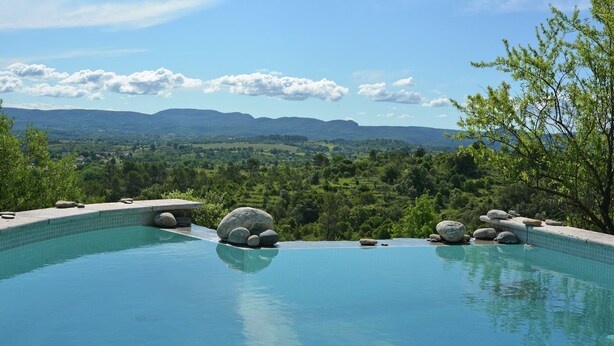A infinity pool with a view of mountains and a clear sky. - Villa in Les Mages with swimming pool (Les Mages)