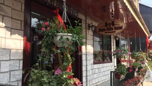 A hotel entrance with a hanging flower planter and a sign reading "Sapa Hills Hotel."