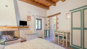 Un dormitorio con cama, escritorio, silla, televisor y armario.