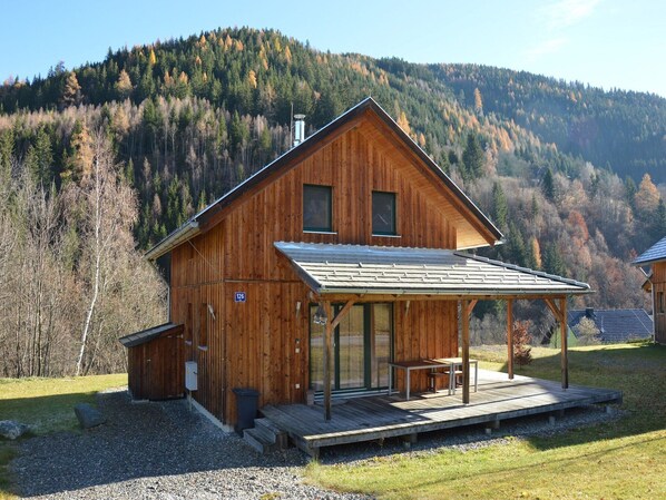 Une cabane en bois dotée d’un porche couvert et d’une plaque portant le numéro 126.