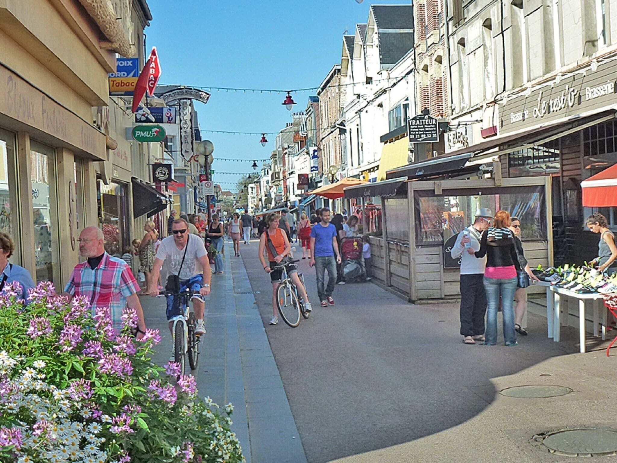 Une rue animée, bordée de boutiques et dotée d’espaces de terrasses.