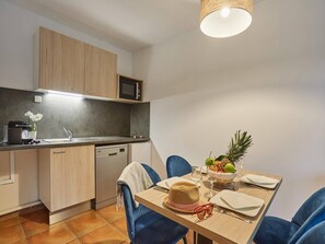A modern kitchen with a dishwasher, microwave, and wooden cabinets. - Coast Retreat with Terrace (Saint Jean de luz)