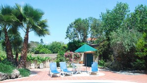 A swimming pool with blue water, surrounded by palm trees and a garden. - Vintage Farmhouse in Soudos Lisbon with pool (Soudos)