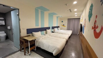 Habitación de hotel con dos camas, una mesita y un baño visible a través de una puerta abierta.