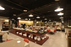 A buffet area with a central serving station, multiple tables, and chairs. - Hotel J Taoyuan (Taoyuan City)