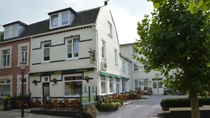 A building with a cafe named "Leew Bier" on the ground floor, featuring outdoor seating and a cobblestone street. - Modern Apartment in Schin op Geul near Valkenburg (Schin op Geul)