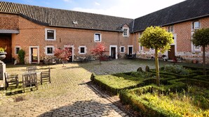 A courtyard with brick buildings, a cobblestone path, and outdoor seating. - Pleasing Holiday Home in Richelle with Garden, Terrace, BBQ (Richelle)