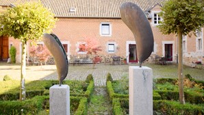 Two abstract sculptures in a courtyard with a brick building in the background. - Pleasing Holiday Home in Richelle with Garden, Terrace, BBQ (Richelle)