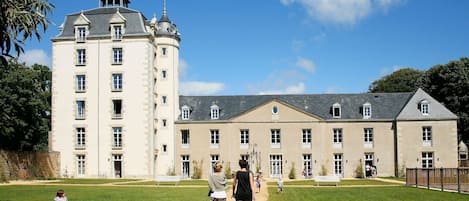 A large, historic building with multiple windows and a central courtyard.